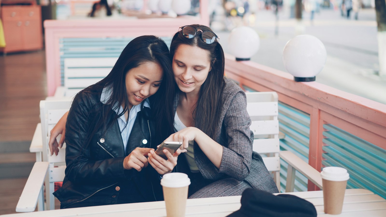 Twee vriendinnen in een café doen samen een test op de telefoon